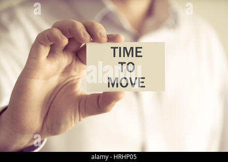 Primo piano su imprenditore tenendo una scheda con il testo il tempo di spostarsi, business Concetto di immagine con soft focus background e tono vintage Foto Stock