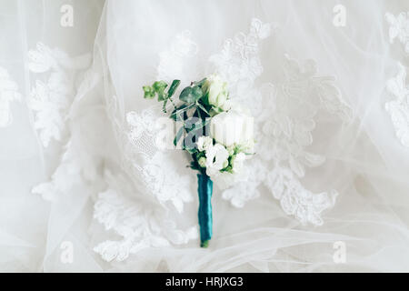 Bella boutonniere su bianco abito da sposa, primo piano Foto Stock