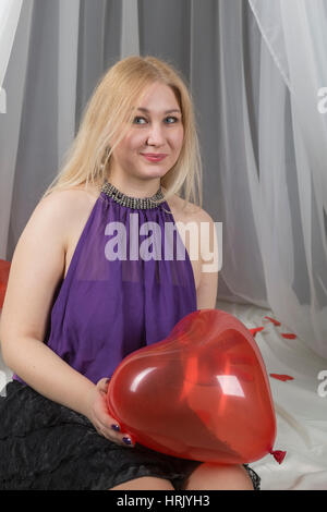 Ragazza giovane con un simbolo dell'amore il giorno di San Valentino in Camera da letto. Foto Stock