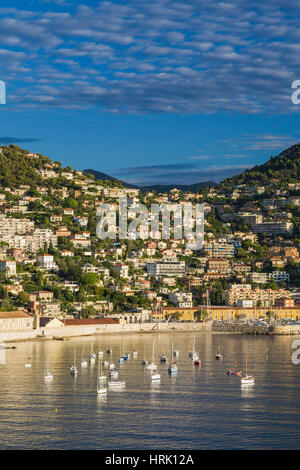 Skyline della città sulla collina e barche a vela nella Baia, Villefrance-sur-Mer, Provenza, Francia Foto Stock