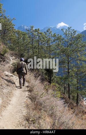 Uomo locale escursionismo in Tiger che saltava Gorge, Yunnan, Cina Foto Stock