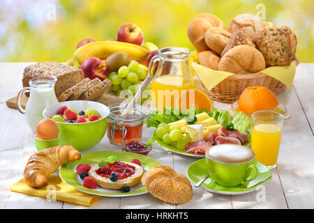 Fuori è servita la prima colazione con una tazza di cappuccino e una grande selezione di cibo Foto Stock