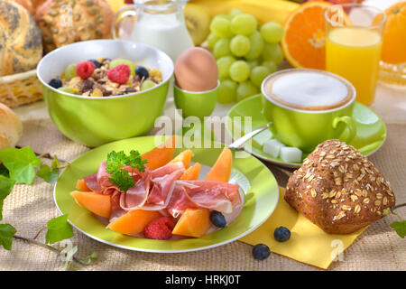 Di cui il tavolo della colazione con melone Honeydew, prosciutto e un sacco di frutta Foto Stock