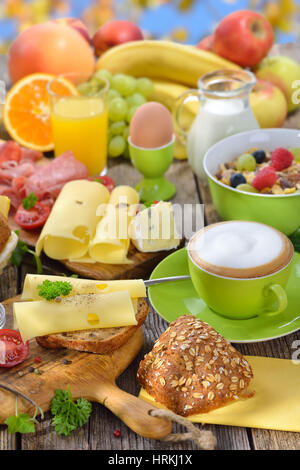 Fuori è servita la prima colazione con una tazza di cappuccino e una grande selezione di cibo Foto Stock