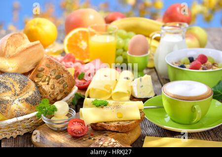 Fuori è servita la prima colazione con una tazza di cappuccino e una grande selezione di cibo Foto Stock