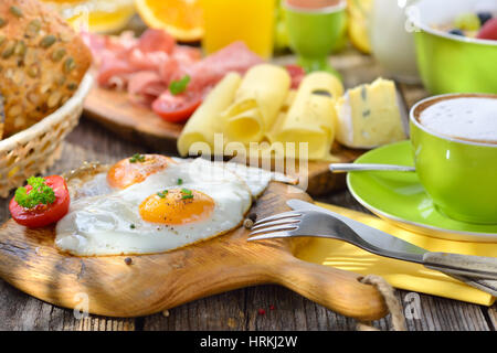 Al di fuori di una lussureggiante servita la prima colazione con uova fritte una vasta selezione di altri alimenti Foto Stock