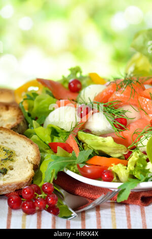 Fresca Insalata estiva con melone Honeydew palle e salmone selvaggio affumicato servita con crostini di pane ciabatta con burro alle erbe aromatiche Foto Stock