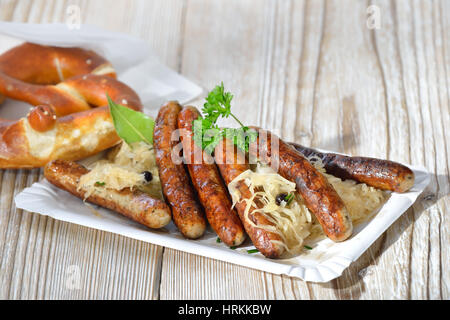 Sei fritto salsicce bavarese da Norimberga servita con crauti e un pretzel Foto Stock