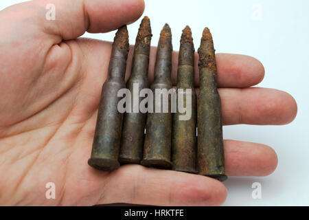 Mano trattiene le vecchie cartucce su uno sfondo bianco. Foto Stock