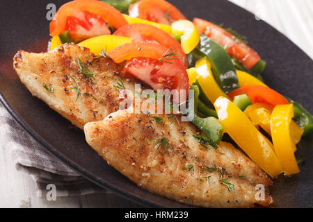 Grigliata di filetti di Tilapia e fresca insalata di verdure su una piastra di close-up orizzontale. Foto Stock