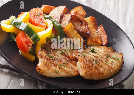 Grigliata di Tilapia filetto, patate fritte, insalata fresca su una piastra di close-up orizzontale. Foto Stock