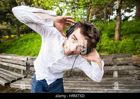 Un giovane uomo a ballare la musica che ascolta sul suo cuffie. Foto Stock