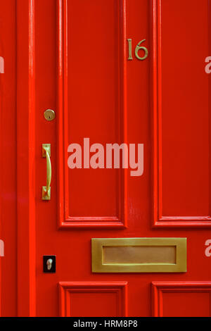 Un dettaglio di close-up shot di un ansa rosso porta di ingresso con una maniglia in ottone e lettera slot in Covent Garden di Londra, Inghilterra Foto Stock