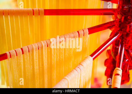 Self-made tagliatelle italiano appeso su una pasta stendino. Foto Stock