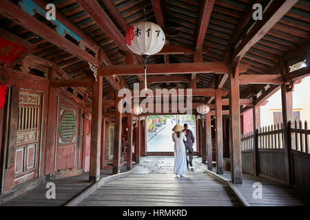 Persone che camminano sul ponte coperto giapponese. Città antica di Hoi An, provincia di Quang Nam, Vietnam. Foto Stock