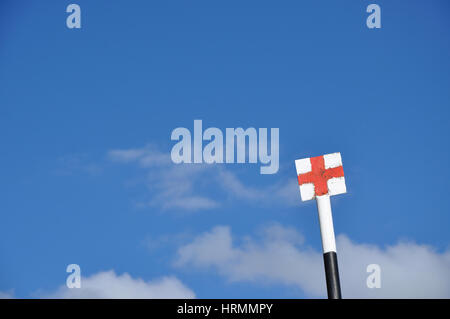 Orientamento per trekking in montagna. La croce rossa su sfondo bianco contro il cielo blu Foto Stock