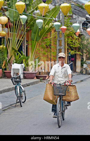 Uomo in bicicletta nella antica città di Hoi An. Quang Nam Provincia, Vietnam. Foto Stock