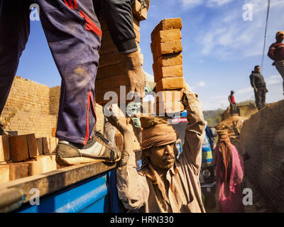 Bagmati, Sviluppo Centrale Regione, Nepal. 3 Mar, 2017. Lavoratori di mattoni di consegnare a un carrello in attesa presso una fabbrica di mattoni in Bagmati, vicino a Bhaktapur. Ci sono quasi 50 fabbriche di mattoni nella valle vicino a Bagmati. Il mattone maker sono molto occupato facendo mattoni per la ricostruzione di Kathmandu, Bhaktapur e di altre città della valle di Kathmandu che sono stati gravemente danneggiati dal 2015 Nepal terremoto. Le fabbriche di mattoni sono stati nella zona di Bagmati per secoli perché l'argilla locale popolare è un materiale grezzo per la posa in opera dei mattoni. La maggior parte dei lavoratori nelle fabbriche di mattoni sono i lavoratori migranti provenienti da così Foto Stock