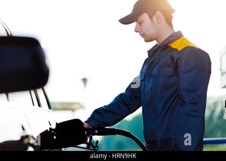 Stazione di gas lavoratore rifornimento auto presso la stazione di servizio Foto Stock