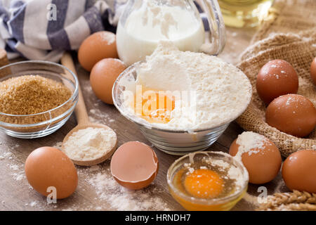 Rompere le uova in farina per fare torte sfondo Foto Stock