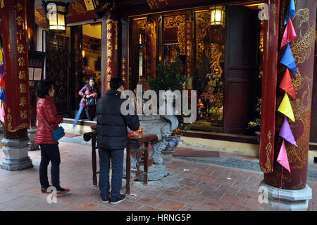 HANOI, VIETNAM - Febbraio 19, 2013: buddista adoratori in preghiera nell'interno del Bac Ma tempio in Hanoi Vietnam Foto Stock