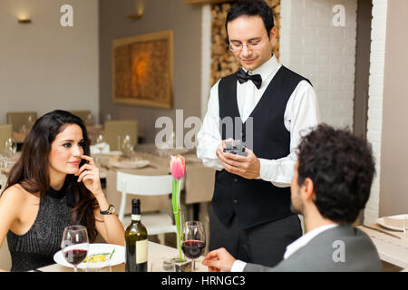 Cameriere prendendo gli ordini in un ristorante Foto Stock