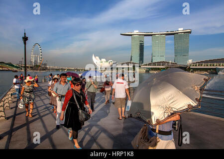 I turisti di fronte al Marina Bay Sands Hotel, ArtScience Museum, ombrellone, Singapore, Asia, Singapore Foto Stock