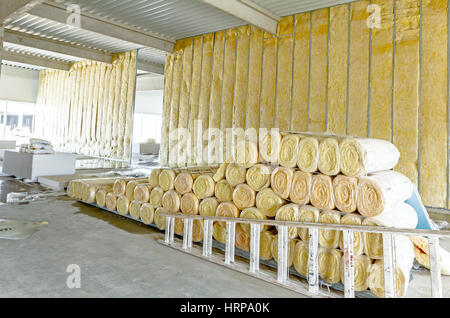 Pila di isolamento termico del materiale in rotolo è avvolta con foglio di cellophane. Utilizzate la scaletta in legno per completare la parete divisoria Foto Stock