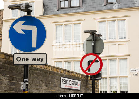 Nessun indicatore di direzione di destra strada britannico segno accanto alla croce ossa paupers cimitero sulla Croce Rossa di modo, Southwark, Londra, Regno Unito Foto Stock