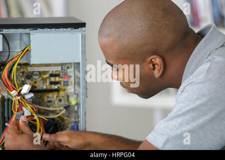 Uomo al lavoro su cablaggio del calcolatore Foto Stock