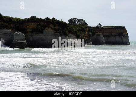 Scogliera confinante con l'oceano a Urenui, la comunità di spiaggia nei pressi di New Plymouth, Isola del nord, Nuova Zelanda Foto Stock