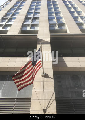 Angolo basso guardando verso la parte superiore di una New York City grattacielo ufficio edificio su una festa giorno nuvoloso con il blu del cielo. Alto edificio di Manhattan, Ne Foto Stock