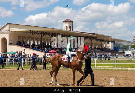 NALCHIK, RUSSIA - giugno 12:Ippodromo in città Nalchik. Prima corsa di cavalli per il premio del Analogichnoi.Il jockey Z.Kashirgov.Giugno 12, 2016 in Nalc Foto Stock