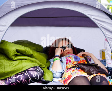 Ragazza adolescente rilassante nella sua tenda a 2010 Womad Festival, Inghilterra Foto Stock