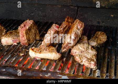 Molti pezzo di carne di manzo la cottura alla griglia su un barbecue Foto Stock