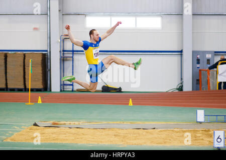 SUMY, Ucraina - 17 febbraio 2017: Serhiy Nykyforov eseguendo il suo salto in lungo in qualifica su ucraino via al coperto e campo championship 2017. Foto Stock