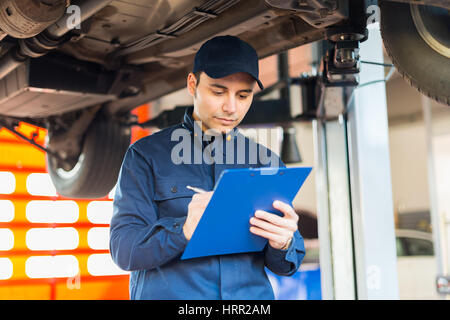 Ritratto di un meccanico al lavoro nel suo garage Foto Stock