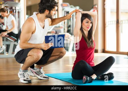 Fitness, sport, della formazione, della palestra e del concetto di stile di vita - donna con personal trainer Foto Stock