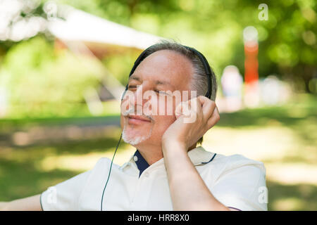 Ritratto di una coppia uomo sorridente ascoltando musica all'aperto Foto Stock