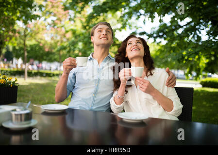 Coppia giovane bere il tè e guardando in alto Foto Stock