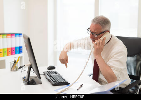 Infastiditi imprenditore avente una discussione mentre si parla al telefono Foto Stock