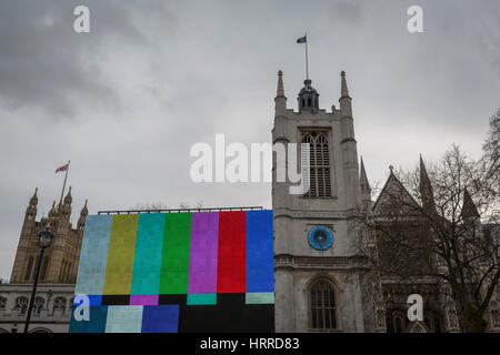 Le barre di colore su un enorme schermo TV visto in piazza del Parlamento e al di fuori di Westminster Abbey, il 20 febbraio 2017, a Londra, in Inghilterra. Barre dei colori SMPTE è una televisione del modello di prova utilizzato nel caso in cui i segnali video NTSC standard è utilizzato, compresi i paesi del Nord America. La società delle immagini in movimento e gli ingegneri televisivi (SMPTE) si riferisce a questo modello di prova come linea direttrice di ingegneria EG 1-1990. Foto Stock