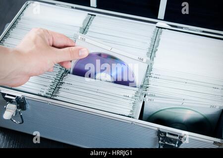 Mano tira il disco in alluminio che porta CD-DVD caso Foto Stock