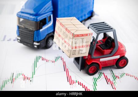 Carrello elevatore a forche giocattoli con le caselle. Concetto di trasporto internazionale di merci su sfondo di business Foto Stock