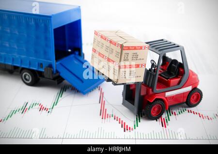 Carrello elevatore a forche giocattoli con le caselle. Concetto di trasporto internazionale di merci su sfondo di business Foto Stock