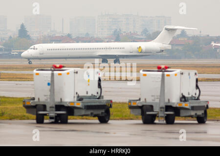 Aeroporto auto bagagli all'aeroporto di Sofia. Carrello di trasporto con bagaglio caricato sulla pista. Foto Stock