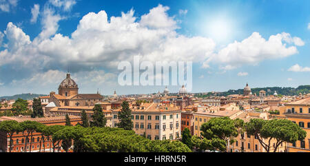 La molla blu cielo con sole luminoso al di sopra di Roma. Vista dal tetto su Roma le vecchie costruzioni. Luminoso paesaggio panoramico della città antica. Foto Stock