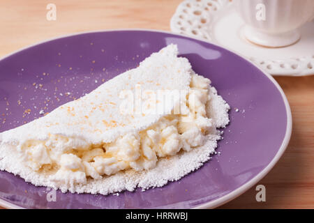 Casabe (ingaggiami, beiju, bob, biju) - flatbread di manioca (tapioca) con ricotta e miele e la tazza di caffè su sfondo di legno. Messa a fuoco selettiva Foto Stock