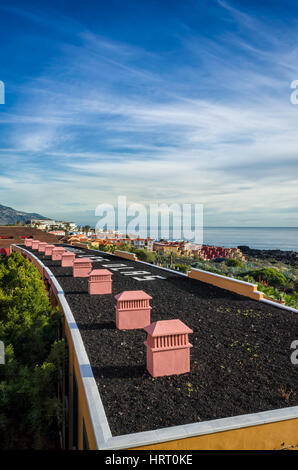 Los Cancajos, La Palma. Una vista dall'Hotel Las Olas appartamenti vacanze guardando fuori verso la costa, nel lungo tetto di appartamenti per le vacanze al di sotto. Si tratta di una chiara mattina di sole con solo qualche luce nuvole nebuloso linger sopra l'oceano. Fotografato con una Ricoh GRII fotocamera. Foto Stock