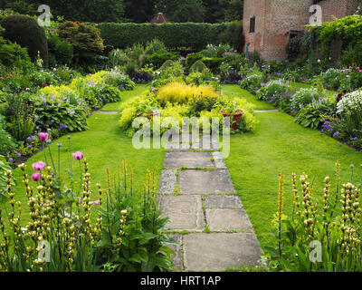 Chenies Manor Sunken giardino nel periodo estivo con dalie e lussureggiante fogliame verde piante, stagno ornamentale, erbaceo frontiere; sentieri erbosi e pavilion. Foto Stock